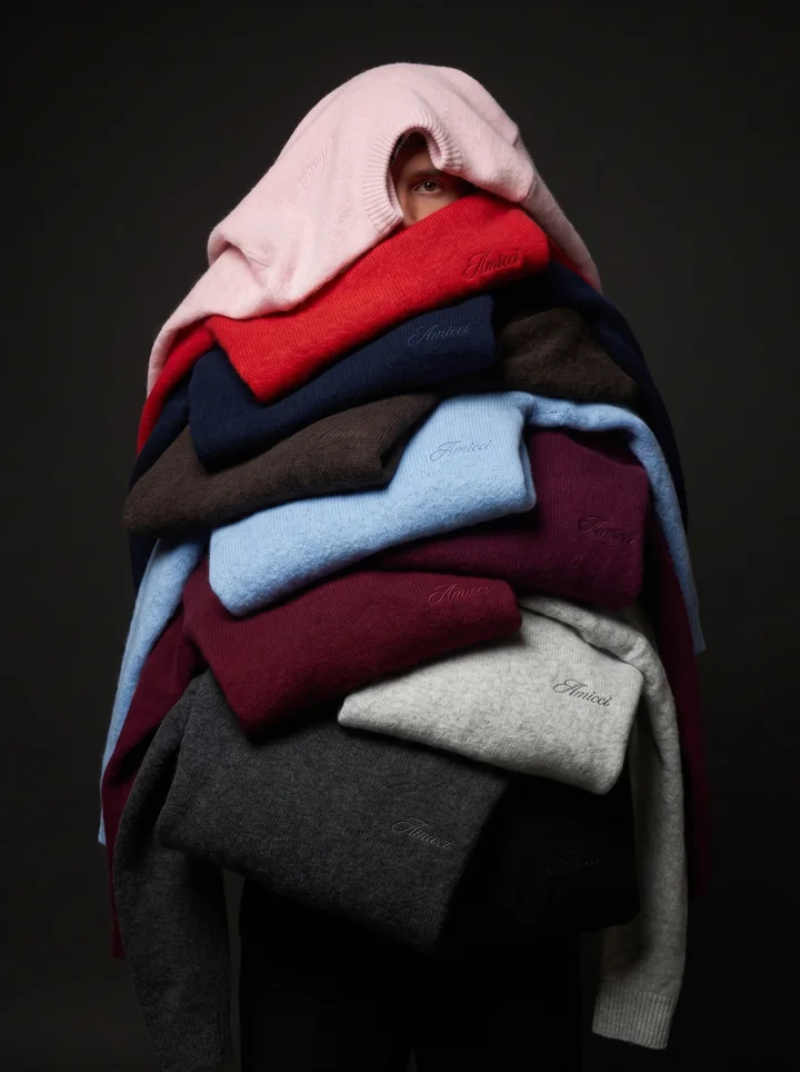 A model wrapped in a sculptural stack of coloured Amicci knitwear