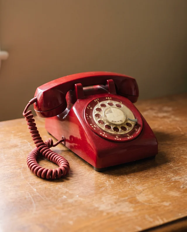 Newly generated standalone prop reference of a red rotary telephone on an oak table