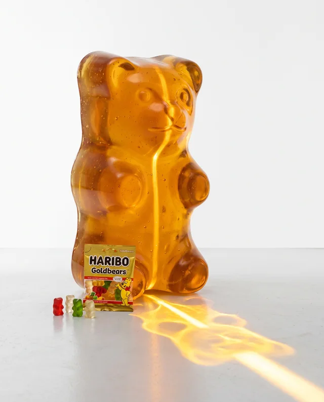 A HARIBO packet beneath a giant translucent golden gummy bear