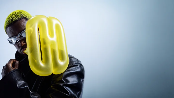 A portrait with acid-yellow hair and a sculptural DOPEARTDEPT symbol